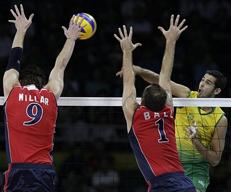 USA's Ryan Millar (9) and Lloy Ball (1) attempt to block a spike from Brazil's Dante Amaral, right, during their men's volleyball gold medal match at the Beijing 2008 Olympics in Beijing